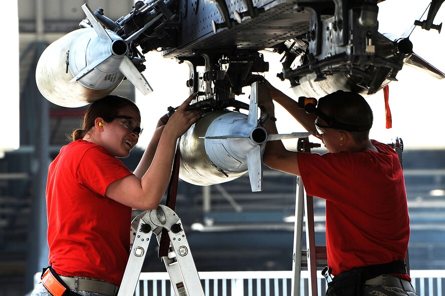 Airmen from the 23rd Aircraft Maintenance Unit load crew attach an inert munition during the Load Crew of the Quarter competition at Dock 7 at Minot Air Force Base, N.D., July 22, 2016. Two weapons load crews, representing the 23rd Bomb Squadron, were timed on their ability to load three inert munitions onto a B-52H Stratofortress. (U.S. Air Force photo/Senior Airman Kristoffer Kaubisch)