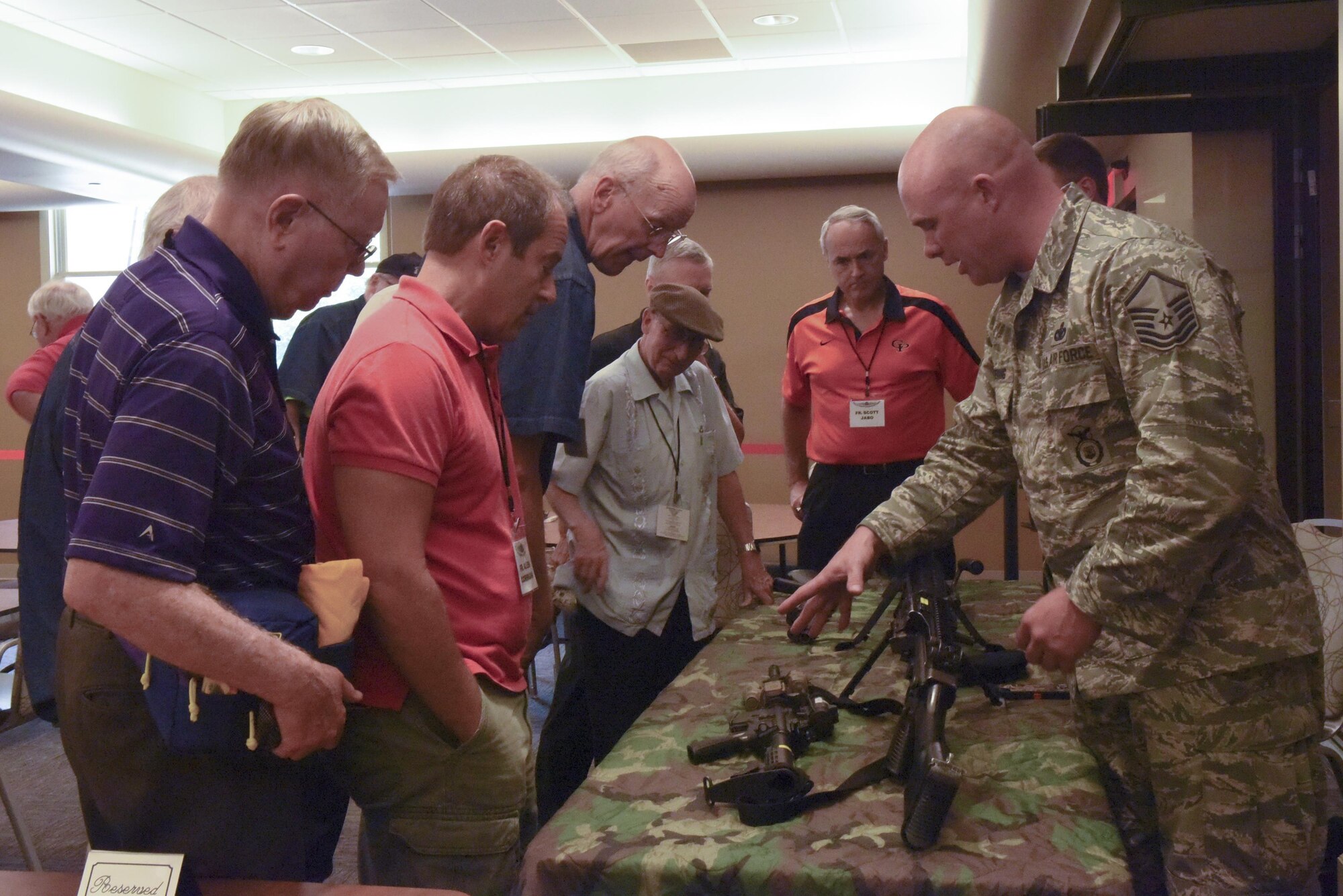 Master Sgt. Michael Boehning, standards and evaluations officer with the 911th Security Forces Squadron, briefs members of the National Association of Priest Pilots on different weapons at the Pittsburgh International Airport Air Reserve Station, July 13, 2016. These priest pilots, or “Flying Padres,” visited the 911th Airlift Wing to learn more about its mission and its Airmen. (U.S. Air Force courtesy photo by Ashley Podrasky)