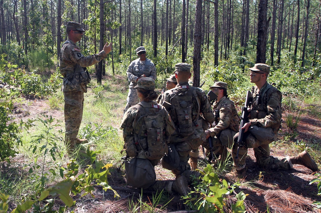 Army drill sergeant, Staff Sgt. Jack Lee of  Company F, 1st Battalion, 34th Infantry Regiment, 165th Infantry Brigade (standing left) and Reserve drill sergeant, Sgt. Leah Anderson of Company D, 518th  Battalion, 2nd Headquarters Brigade, 98th Training Division (Initial Entry Training) (standing right) facilitate an after action review (AAR) being conducted by their Basic Combat Training (BCT) Soldiers following their patrol near their Command Post (CP) during their BCT Company's final field training exercise (FTX)  July 20 at Fort Jackson, S.C. July before their graduation. The final FTX allows the Soldiers to apply all of their training under the most rigorous and stressful conditions similar to real combat operations. (U.S. Army photo by Sgt. Javier Amador)