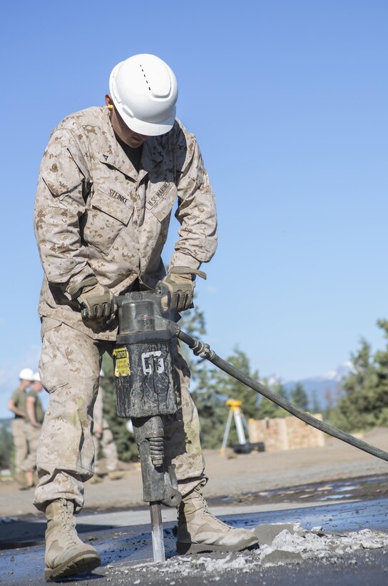 Lance Cpl. John Steinke, a combat engineer with Engineer Services Company, Combat Logistics Battalion 23, Combat Logistics Regiment 4, 4th Marine Logistics Group, Marine Forces Reserve, jack hammers a portion of the ground in preparation for a new stairwell allowing better access to a storage facility during Exercise Forest Rattler in Bend, Ore., July 20, 2016. During the exercise Reserve Marines not only honed their skills as an engineering company but worked with the U.S. Forest Service to complete various projects to benefit the local community. (U.S. Marine Corps photo by Sgt. Sara Graham/ Released)