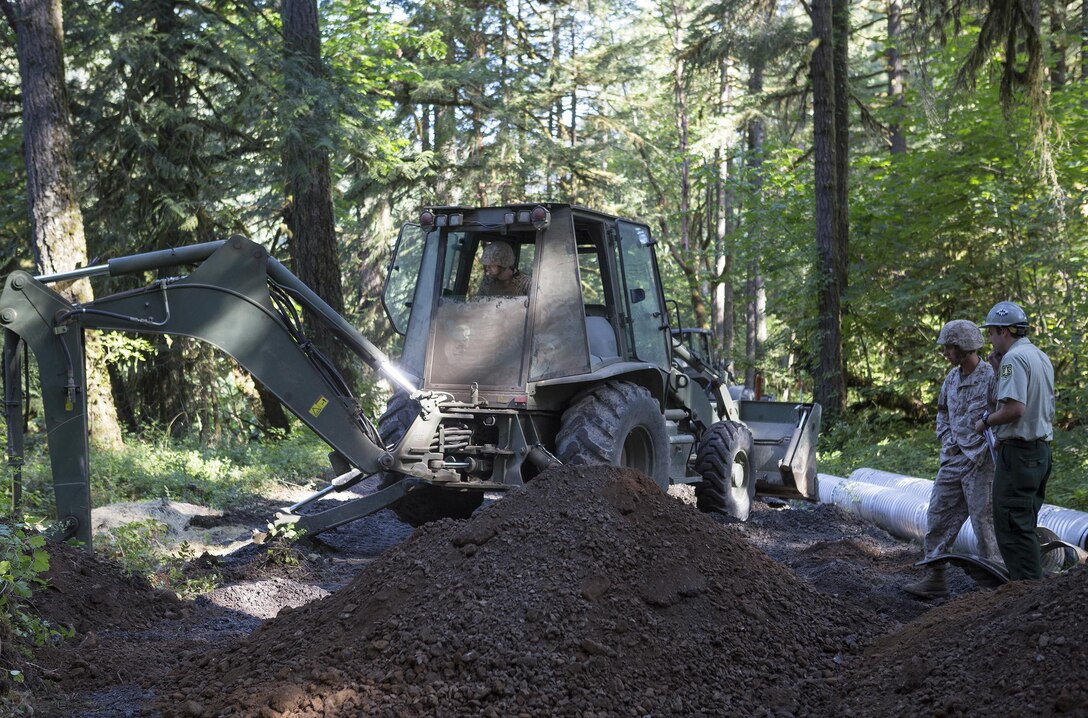Marines with Engineer Services Company, Combat Logistics Battalion 23, Combat Logistics Regiment 4, 4th Marine Logistics Group, Marine Forces Reserve, work with the U.S. Forest Service during Exercise Forest Rattler to clean and repair culverts in roads running through the Willamette National Forest in Oakridge, Ore., July 21, 2016. The exercise not only allowed the Marines to give back to the community by repairing roads they utilize, but gave them time to hone their skills as an engineering service company. (U.S. Marine Corps photo by Sgt. Sara Graham/ Released)