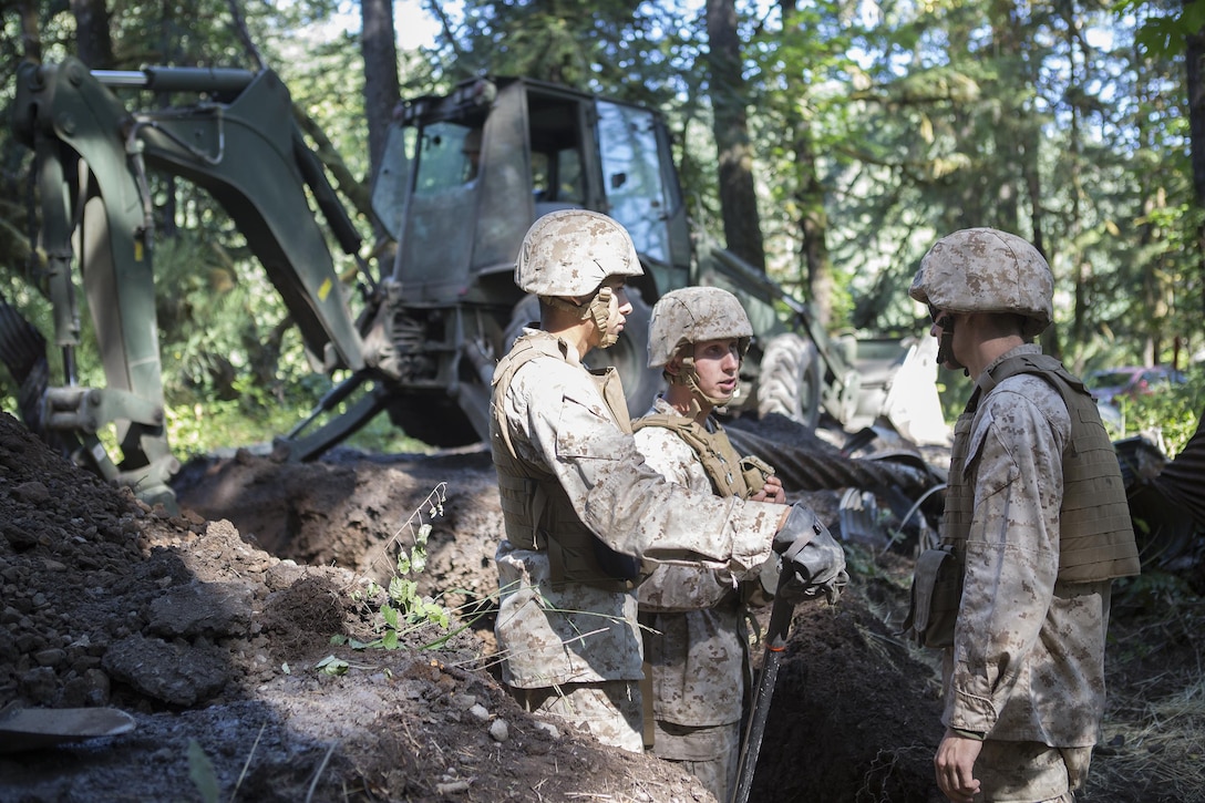 Marines with Engineer Services Company, Combat Logistics Battalion 23, Combat Logistics Regiment 4, 4th Marine Logistics Group, Marine Forces Reserve, discuss how to clean and repair a culvert in the road while working with the U.S. Forest Service during Exercise Forest Rattler in Oakridge, Ore., July 21, 2016. The exercise not only allowed the Marines to give back to the community by repairing roads they utilize, but gave them time to hone their skills as an engineering service company and complete a wide range of horizontal and vertical engineering projects. (U.S. Marine Corps photo by Sgt. Sara Graham/ Released)