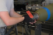 An Airman from the 5th Munitions Squadron installs a nose fuse on an MK-82 bomb at Minot Air Force Base, N.D., July 20, 2016. Airman have to ensure the timer is set to the proper setting and properly labeled before finalizing production.  (U.S. Air Force photo/Airman 1st Class Jessica Weissman)