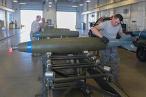 Airman 1st Class Derek Merkley, a conventional munitions crew member assigned to the 5th Munitions Squadron, installs a fin onto an inert bomb at Minot Air Force Base, N.D., July 20, 2016. These inert bombs were refurbished for the recent Load Crew of the Quarter competition. (U.S. Air Force photo/Airman 1st Class Jessica Weissman)