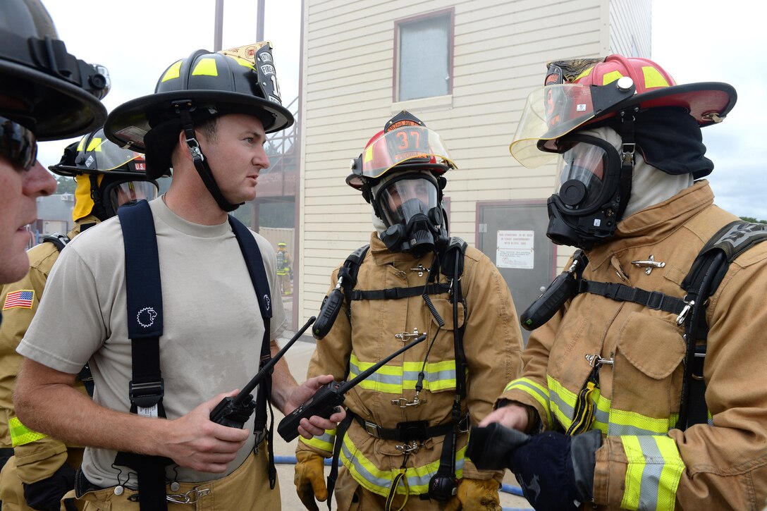 Air Force Tech. Sgt. Samuel Deveral, Staff Sgt. Joshua England and Staff Sgt. Adam King discuss structural live-fire training procedures before entering a burning facility as part of Patriot North 16 at Volk Field, Wis., July 17, 2016. Deveral is a firefighter assigned to the West Virginia Air National Guard’s 167th Civil Engineer Squadron. England and King are firefighters assigned to the Illinois Air National Guard’s 182nd Civil Engineer Squadron. Patriot North 2016 is an annual exercise to test the National Guard’s capabilities and develop working relationships with first responders and government agencies. Air National Guard photo by Senior Master Sgt. David H. Lipp