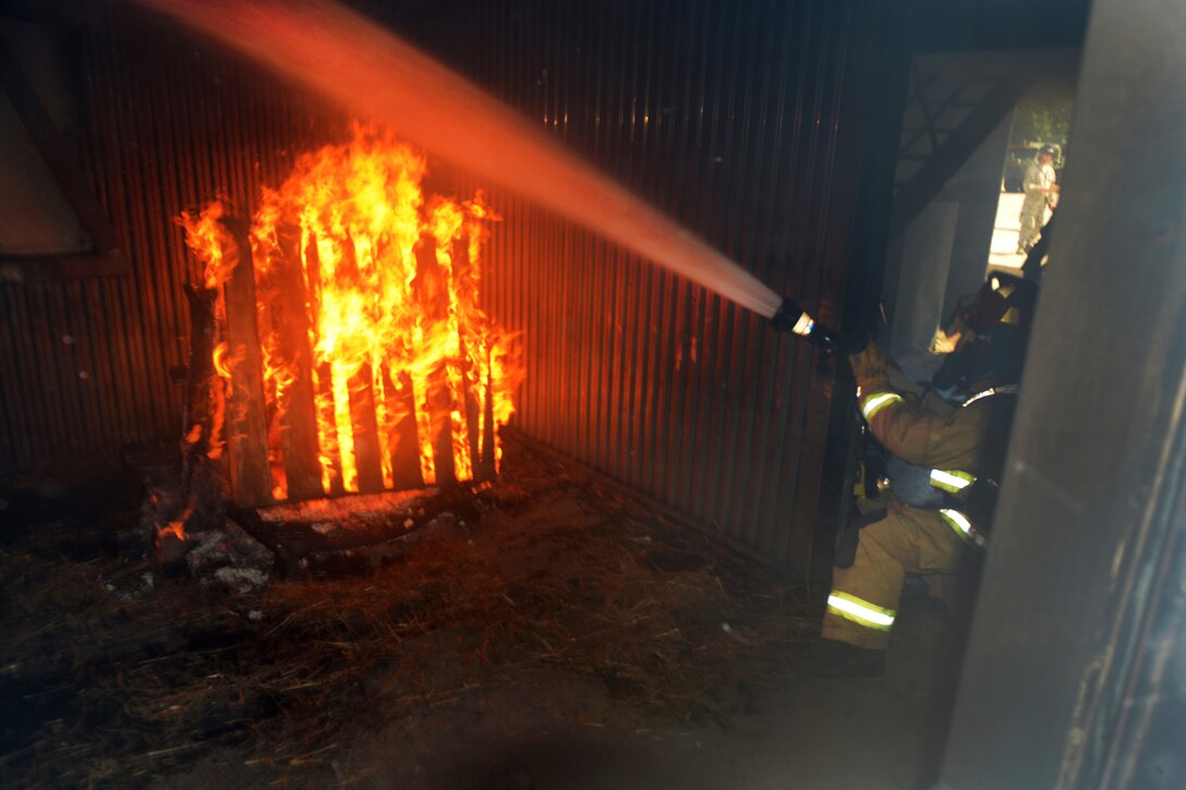 Air Force Airman 1st Class Randle Taborn sprays water onto a fire during structural live-fire training at exercise Patriot North 16 at Volk Field, Wis., July 17, 2016. Taborn is a firefighter assigned to the Illinois Air National Guard’s 182nd Civil Engineer Squadron. Air National Guard photo by Senior Master Sgt. David H. Lipp