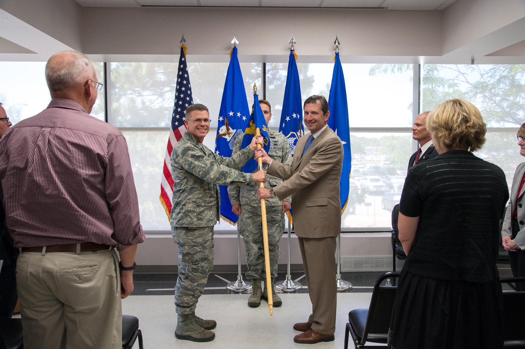 Brig. Gen. Steven J. Bleymaier, Ogden Air Logistics Complex commander (left), passes the 309th Commodities Maintenance Group guidon to incoming group director, Theodore W. Eaton, during a change of leadership ceremony at Hill AFB, Utah, July 7, 2016. (U.S. Air Force photo by R. Nial Bradshaw)