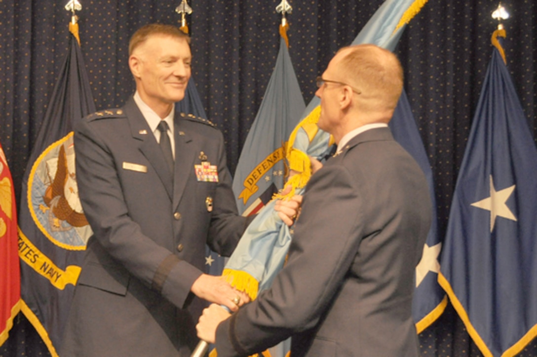 Air Force Lt. Gen. Andy Busch, DLA director, hands the organization colors to Air Force Brig. Gen. Martin Chapin, incoming DLA Energy commander, in a ceremony at Fort Belvoir, Virginia, July 22.