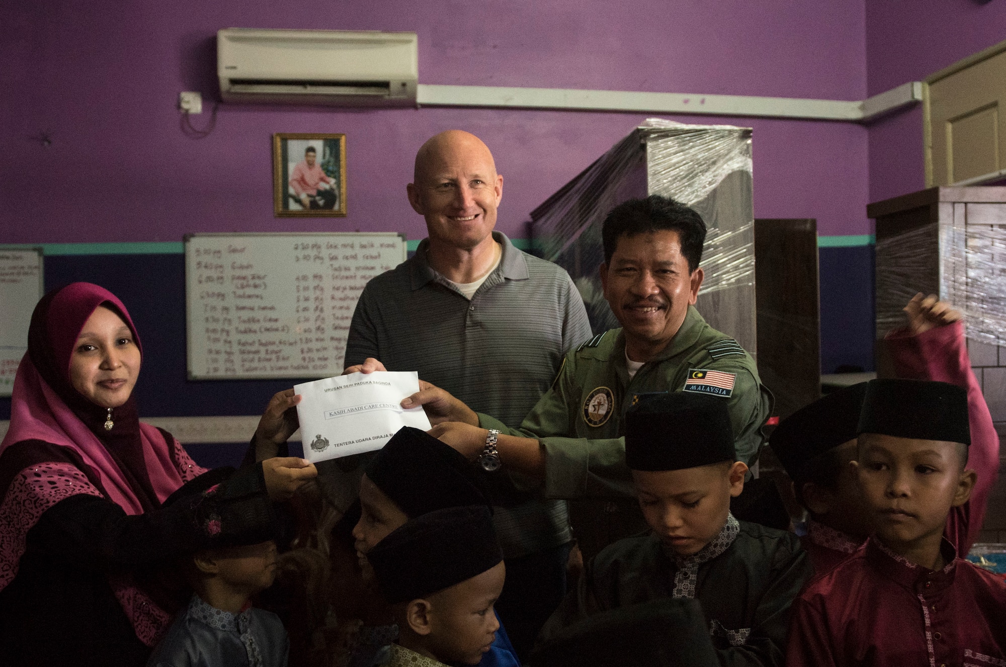 Col. Travis Rex, USAF Exercise Director and Col. Sun Thong, RMAF Exercise Director present a monetary donation to the Kasih Abadi Care Center, during Cope Taufan 16 in Seberan Jaya, Pulau Pinang, July 23, 2016. As part of a community relations event USAF and RMAF visited two local orphanages, donated money and provided furniture to children in need. CT 16 is a PACAF-led exercise that reinforces U.S. Pacific Command Theater Security Cooperation goals for the Southeast Asian region and demonstrates U.S. capability to project forces strategically in a combined, joint environment.  More than 450 Airmen are participating, as well as four U.S. Air Force airframes. (U.S. Air Force photo by Tech. Sgt. Araceli Alarcon)