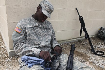 U.S. Army Pfc. Keston Alonzo of the 982nd Combat Camera Company cleans his weapon after conducting weapons qualification at Fort Bragg, NC on July 16, 2016. The 982nd perfoms this training annually to maintain unit readiness. (U.S. Army Photo by Spc. Kwamel Hargett/Released)