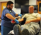Phlebotomist Jay Cannata checks on Master Sgt. Doug Kalota, a C-130 Hercules crew chief with the 914th Aircraft Maintenance Squadron, as he donates blood on July 21, 2016. The American Red Cross had more than 20 base personnel donate, making it the most successful drive on base this year. (U.S. Air Force photo by Staff Sgt. Richard Mekkri/released)