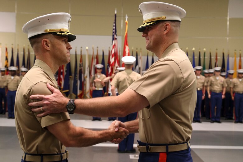 U.S. Marine Corps Maj. Paul B. Bock, right, shakes hands with U.S. Marine Corps Maj. Luke A. Sauber following the passing of the organizational colors during Recruiting Station Frederick’s change of command ceremony June 28, 2016 at Fort Detrick. The passing of the colors signifies a formal transfer of authority and responsibility from one commanding officer to another. Bock is the outgoing commanding officer of the recruiting station, while Sauber is the incoming commanding officer. 