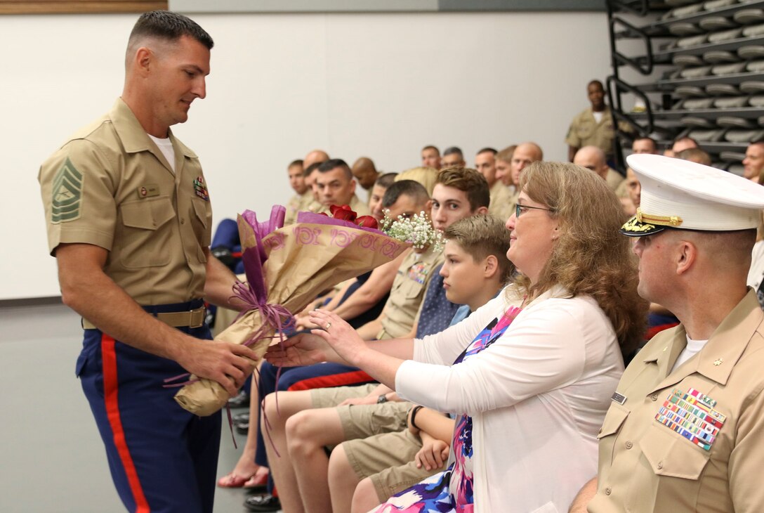 Jennifer Bock receives flowers from Marine Corps Master Sgt. Michael Nash during Recruiting Station Frederick’s change of command ceremony June 28, 2016 at Fort Detrick. The flowers were in recognition of her support, dedication and devotion to her husband’s assignment as Recruiting Station Frederick’s commanding officer. Nash is a recruiter instructor with the station. 