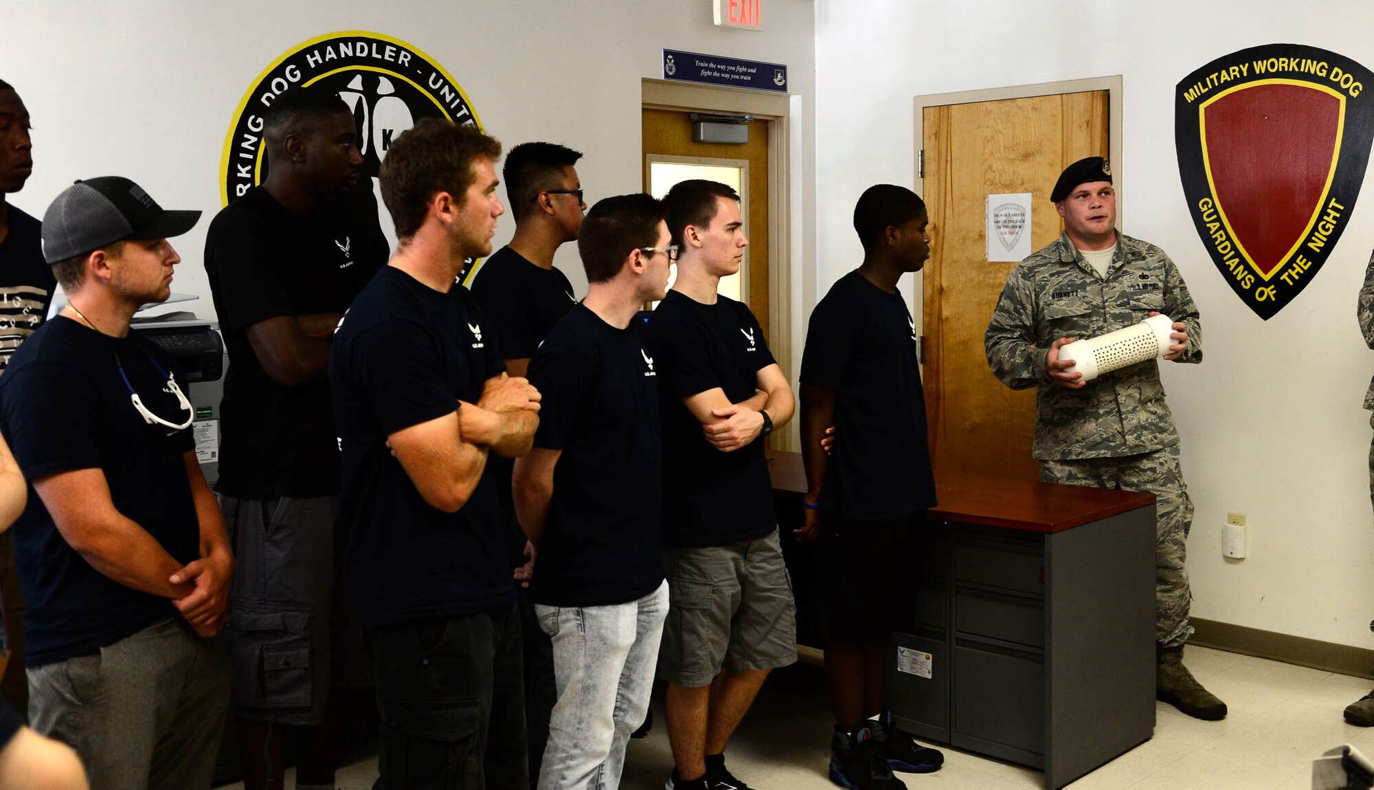 Staff Sgt. Joshua Burnett, a military working dog (MWD) handler assigned to the 6th Security 
Forces Squadron, explains the training required for MWD teams at MacDill Air Force Base, Fla., 
July 22, 2016. Members from the St. Petersburg Delayed Entry Program visited the base to learn 
about the military community and various career fields. (U.S. Air Force photo by Senior Airman 
Tori Schultz)
