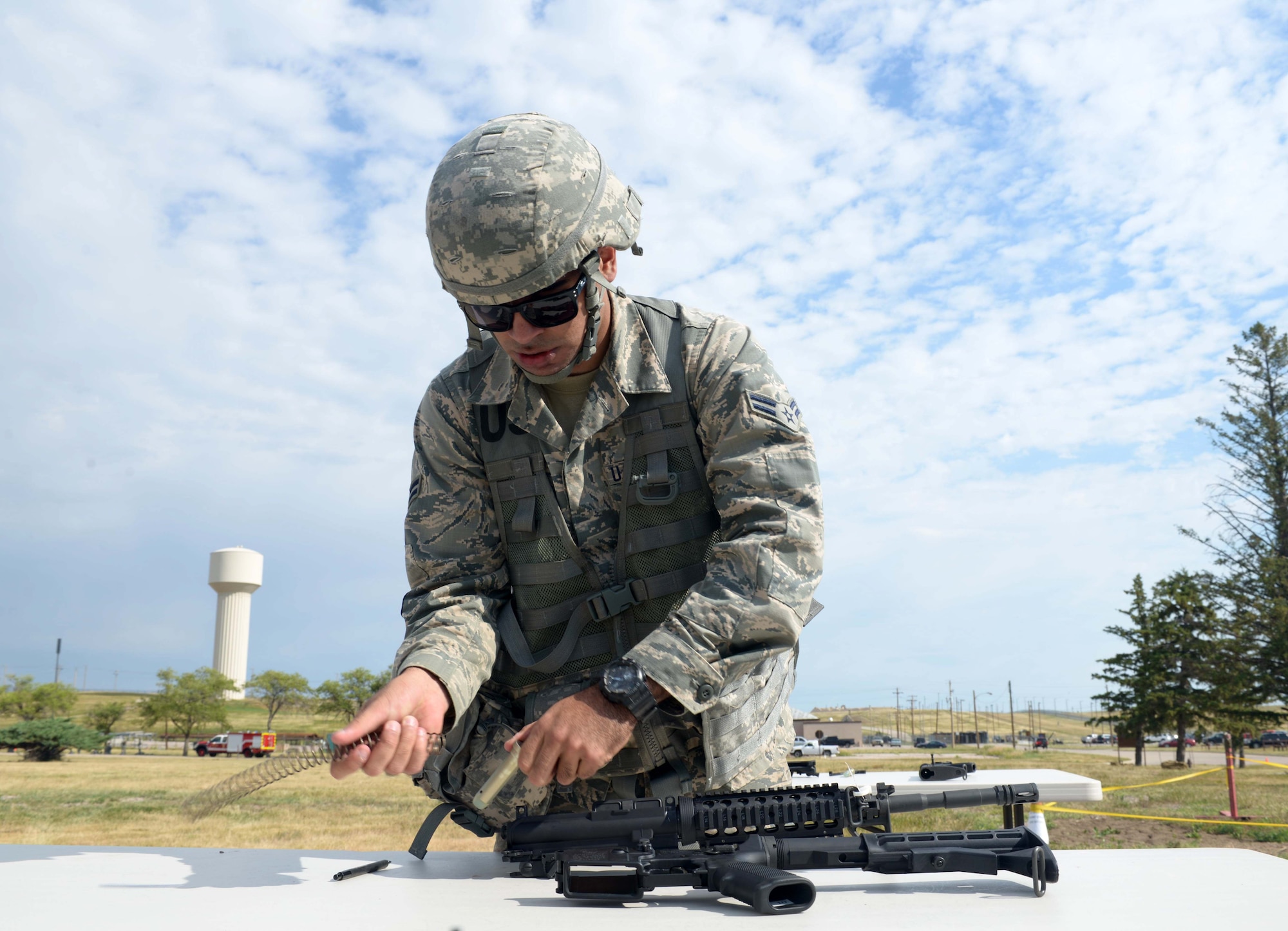 Airman 1st Class Joshua Torres, a power production apprentice assigned to the 28th Civil Engineer Squadron, disassembles an M4 during the Prime Base Engineer Emergency Force (BEEF) challenge at Ellsworth Air Force Base, S.D., July 22, 2016. During the M4 relay, an Airman runs down to field-strip an M4, then tags another Airman who then runs back to the M4 to reassemble and function check the weapon. (U.S. Air Force photo by Airman Donald Knechtel) 