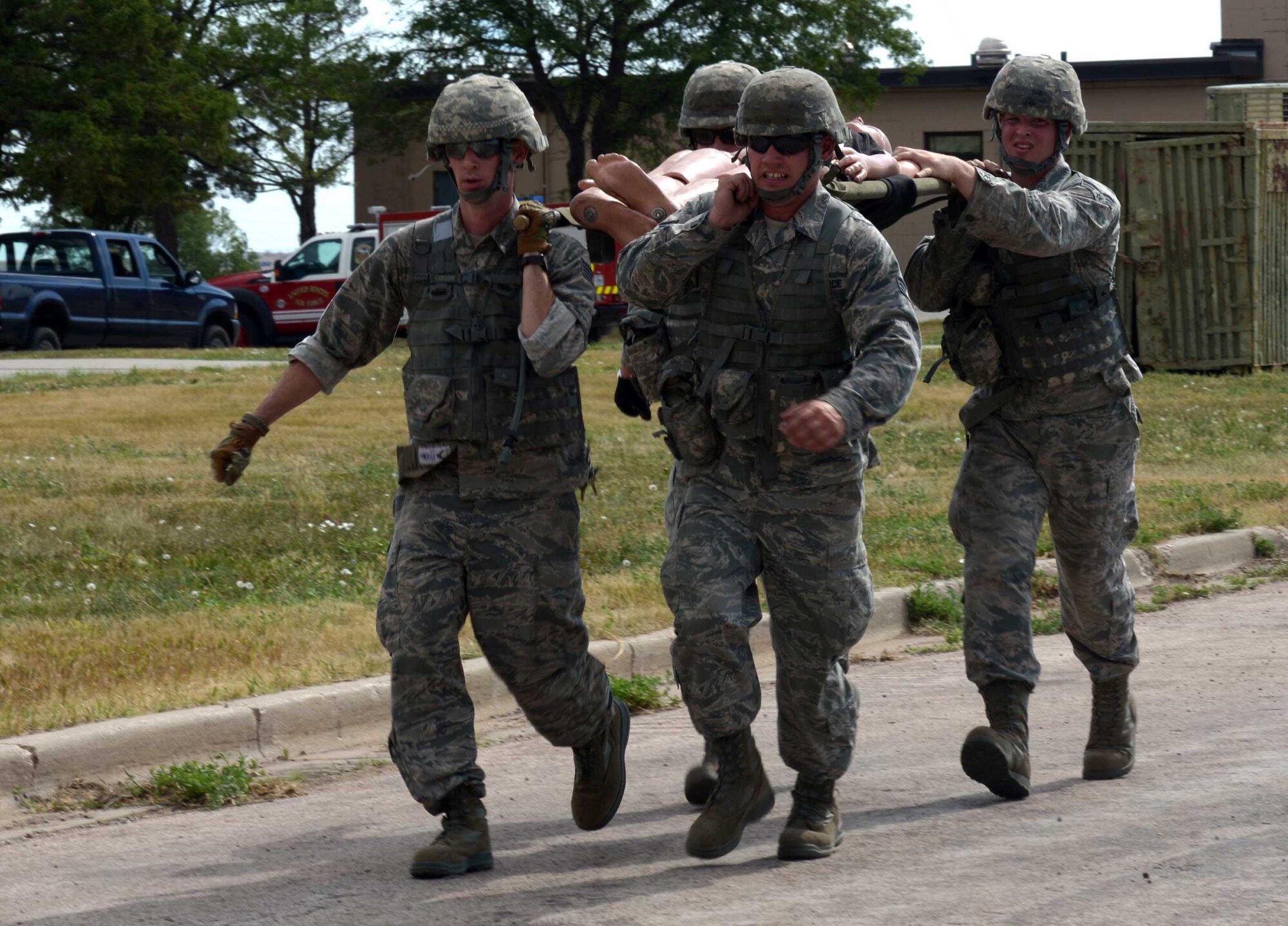 Airmen with the 28th Civil Engineer Squadron litter carry a training dummy during the Prime Base Engineer Emergency Force (BEEF) challenge at Ellsworth Air Force Base, S.D., July 22, 2016. The purpose of the Prime BEEF challenge is a way to put field experience to the test in a competitive environment. (U.S. Air Force photo by Airman Donald Knechtel)