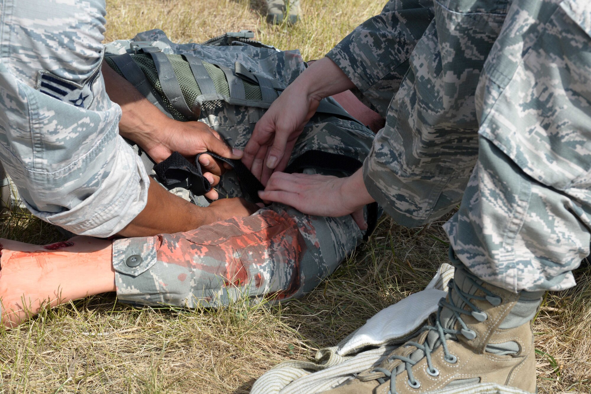 Airmen treat wounds on volunteer casualties at the Self Aid Buddy Care (SABC) station during the Prime Base Engineer Emergency Force (BEEF) challenge at Ellsworth Air Force Base, S.D., July 22, 2016. The Prime BEEF challenge consists of five events such as the Litter Carry, Six Passenger Push, SABC, M4 relay and Battle Buddy stations. (U.S. Air Force photo by Airman Donald Knechtel) 