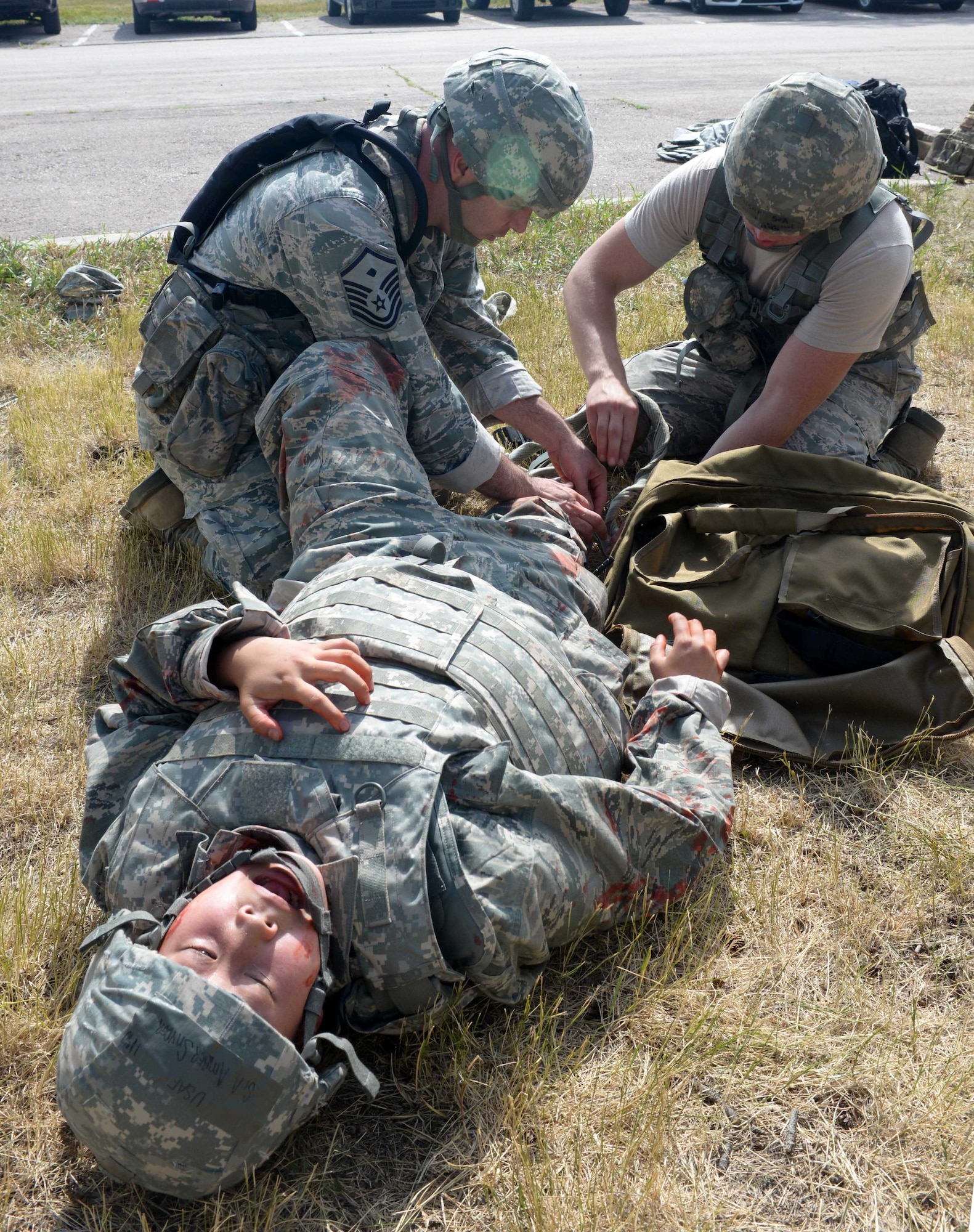 Airmen treat wounds on a volunteer casualty at the Self Aid Buddy Care (SABC) station during the Prime Base Engineer Emergency Force challenge at Ellsworth Air Force Base, S.D., July 22, 2016. The Prime BEEF challenge was created to put field experience to the test in a competitive environment. (U.S. Air Force photo by Airman Donald Knechtel) 