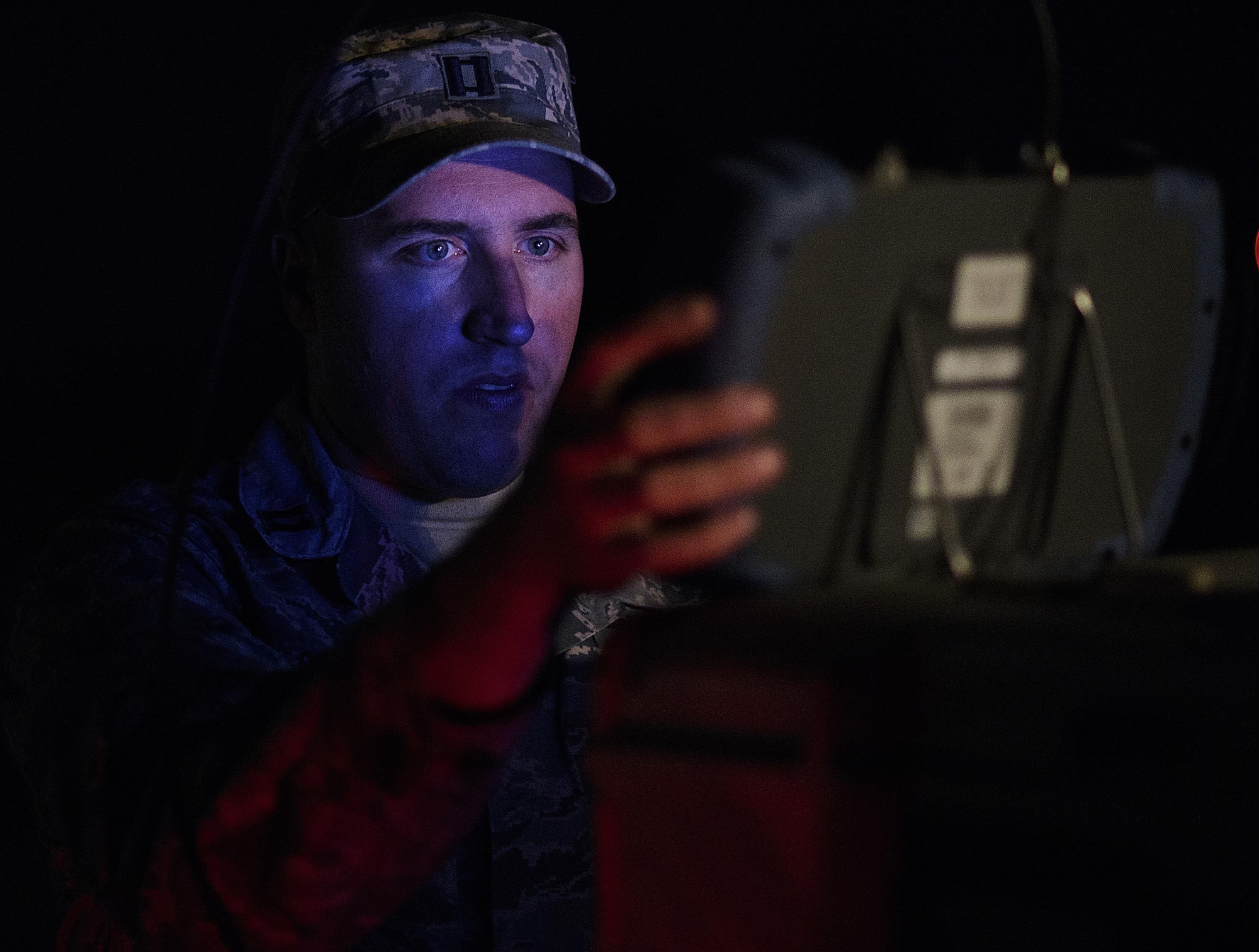 Using minimum light so he can't be seen by exercise Red Flag players, Capt. Brian Goodman, 527th Space Aggressors, fine-tunes his equipment before attempting to degrade a fighter squadron's space capabilities, July 21, 2016 at Nellis Air Force Base, Nevada. “There are adversaries who see how much space brings to the table and how much space has become critical to us in waging and winning wars. They want to take that piece away,” said Goodman. (U.S. Air Force photo/Tech. Sgt. David Salanitri)