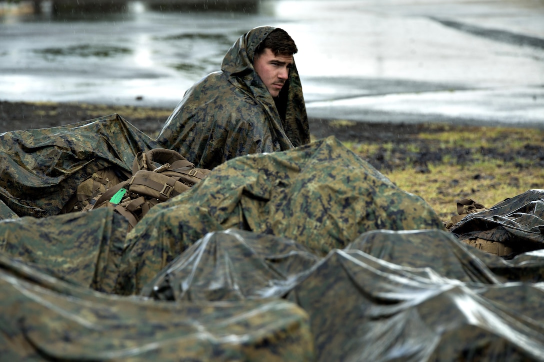 160714-M-PQ336-002 POHAKULOA TRAINING AREA, Hawaii (July 15, 2016) — U.S. Marine Lance Cpl. William Ring keeps dry from the rain at Pohakuloa Training Area, Hawaii, July 15, 2016. Marines with III Marine Expeditionary Force are participating in Rim of the Pacific 2016, a multinational exercise, from June 29 to Aug. 8 in and around the Hawaiian Islands. The Marines of III MEF are headquartered in Okinawa, Japan, where they execute a wide range of military operations in the Pacific region. Ring, a native of Lendon, New Jersey, is a machine gunner with Fox Company, 2nd Battalion, 3rd Marine Regiment, which supports III MEF. (U.S. Marine Corps photo by Cpl. Isaac Ibarra)