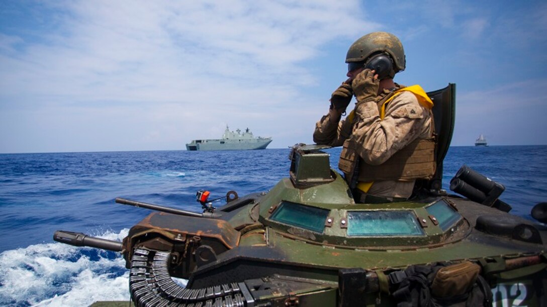 Cpl. Ryan Dills communicates with other assault amphibious vehicles while traveling from amphibious assault ship USS San Diego to Royal Australian Navy Canberra class amphibious ship HMAS Canberra (L02) in the Pacific Ocean, July, 18 2016. The Marines are participating in the Rim of the Pacific 2016, a multinational military exercise, from June 29 to Aug. 4 in and around the Hawaiian Islands. (U.S. Marine Corps photo by Staff Sgt. Christopher Giannetti)