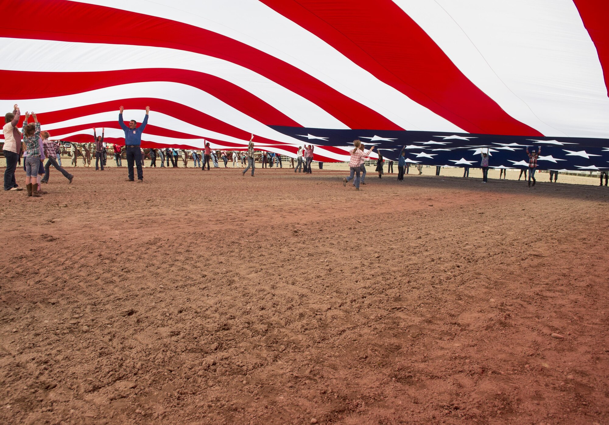 Members of the military and local community unravel the American flag at Frontier Park in Cheyenne, Wyo., July 25, 2016. More than 200 volunteers participated in this year’s Military Monday event. (U.S. Air Force photo by Senior Airman Malcolm Mayfield)