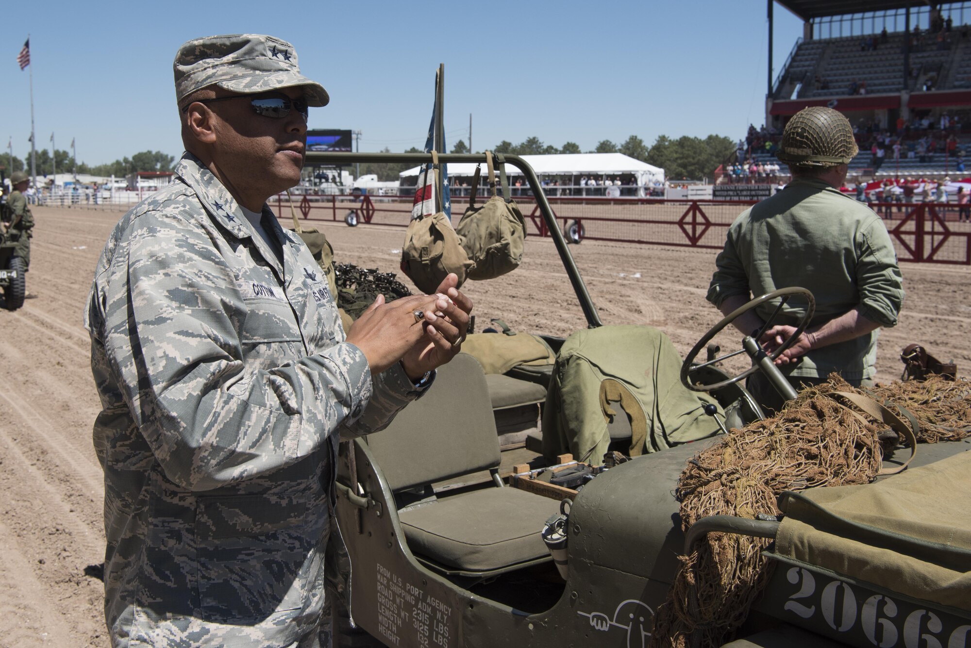 Maj. Gen. Anthony Cotton, 20th Air Force and Task Force 214 commander, applauds at the end of the singing of the national anthem during Military Monday at Frontier Park in Cheyenne, Wyo., July 25, 2016. Military Monday is free for all U.S. military members to attend during Cheyenne Frontier Days. (U.S. Air Force photo by Staff Sgt. Christopher Ruano)