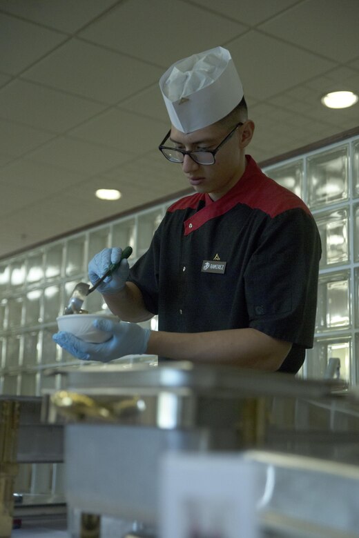 Lance Cpl. Diego Ramirez prepares to serve a dish during the Futenma Mess Hall Chef of the Month competition July 22 on Marine Corps Air Station Futenma, Okinawa, Japan. The monthly competition is an opportunity for the Marines who are performing well in the workplace and seeking opportunities to better themselves through merit boards and other events. During the competition, the contestants must plan a full multi-course meal, cook the dishes and serve it to a panel of judges who evaluate their meal based on taste, appearance, originality and the Marines’ oral presentations explaining each course. Ramirez is a food service specialist assigned to the MCAS Futenma Mess Hall and is a Baker’s Hill, California, native. (U.S. Marine Corps photo by Cpl. Janessa K. Pon)