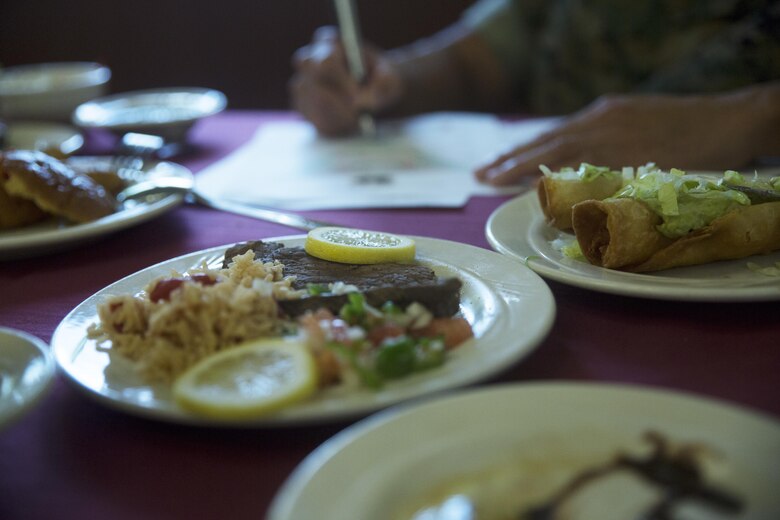 A judge writes comments while serving on the judges panel for the Futenma Mess Hall Chef of the Month competition July 22 on Marine Corps Air Station Futenma, Okinawa, Japan. The monthly competition is an opportunity for the Marines who are performing well in the workplace and seeking opportunities to better themselves through merit boards and other events. During the competition, the contestants must plan a full multi-course meal, cook the dishes and serve it to a panel of judges who evaluate their meal based on taste, appearance, originality and the Marines’ oral presentations explaining each course.