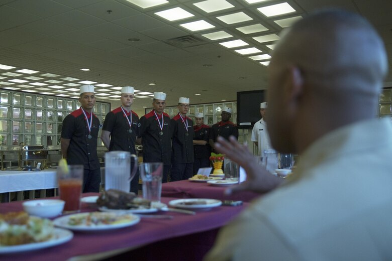 Contestants in the Futenma Mess Hall Chef of the Month competition receive critiques after receiving awards for their performance July 22 on Marine Corps Air Station Futenma, Okinawa, Japan. The monthly competition is an opportunity for the Marines who are performing well in the workplace and seeking opportunities to better themselves through merit boards and other events. During the competition, the contestants must plan a full multi-course meal, cook the dishes and serve it to a panel of judges who evaluate their meal based on taste, appearance, originality and the Marines’ oral presentations explaining each course.
