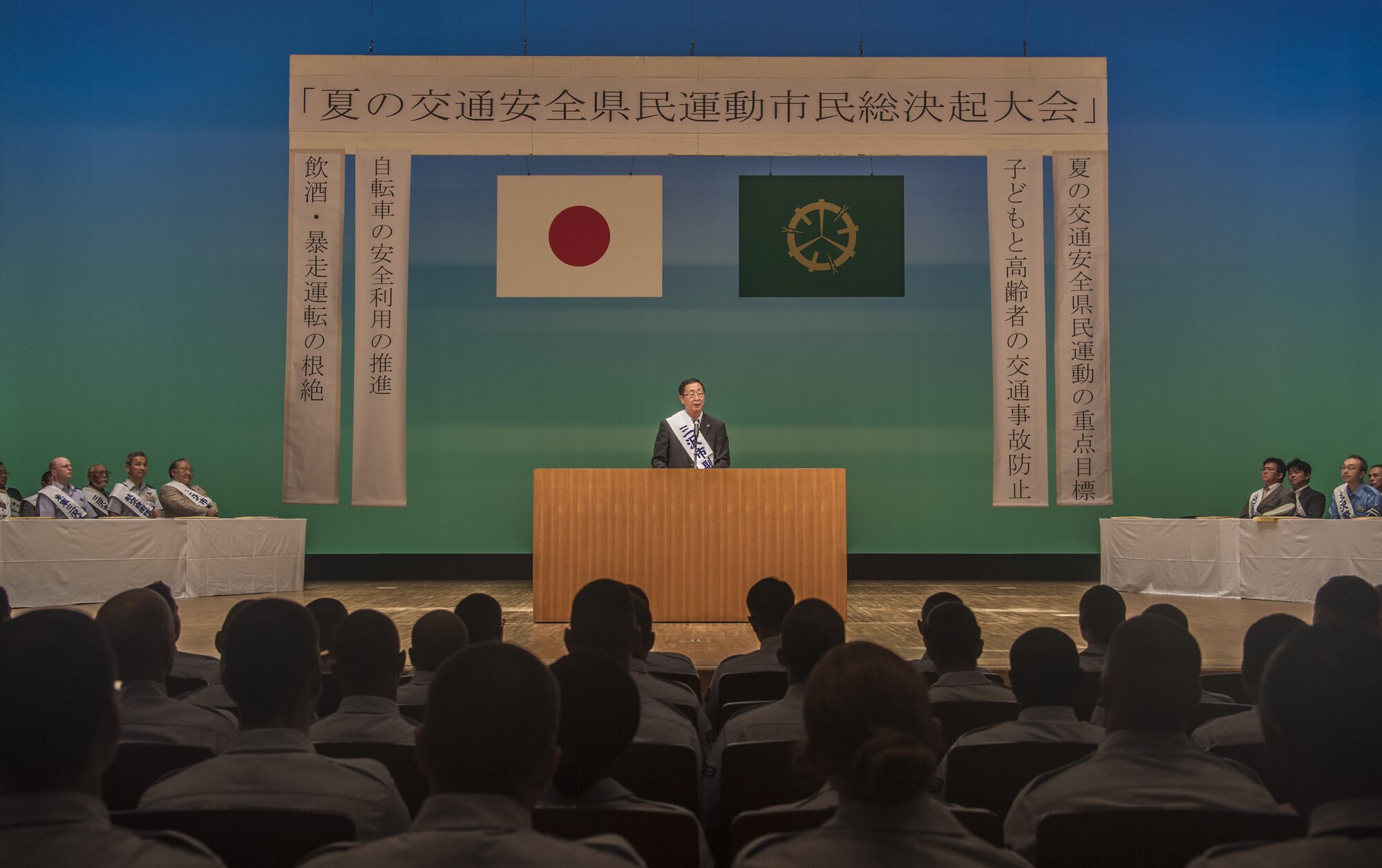 Kazumasa Taneichi, the mayor of Misawa City, speaks to an audience during the 24th Annual Traffic Safety Day in Misawa City, Japan, July 22, 2016. The event beckoned more than 100 service members from Misawa Air Base to help promote traffic safety awareness and the prevention of vehicle accidents. (U.S. Air Force photo by Senior Airman Jordyn Fetter)