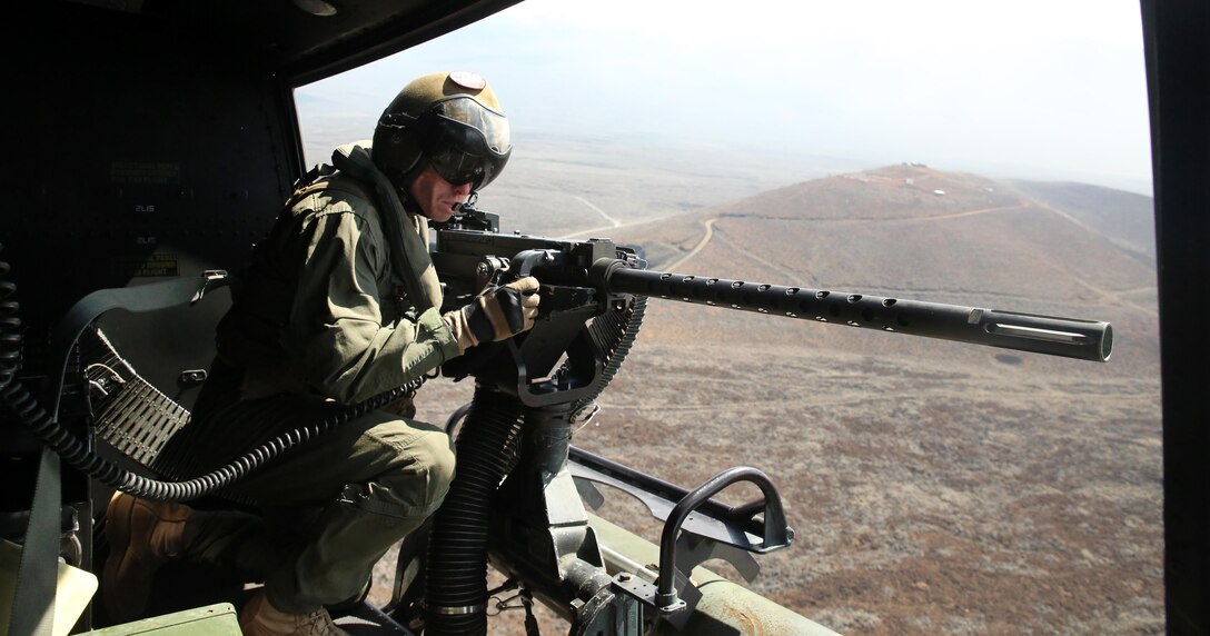 Cpl. Christopher Neumann aims his GAU-21 .50 caliber machine gun during a close air support exercise at Pohakuloa Training Area, Hawaii, July 19, 2016. Neumann is participating in Rim of the Pacific 2016, a multinational military exercise, from June 29 to Aug. 8 in and around the Hawaiian Islands. RIMPAC offers the U.S. military the opportunity to train with partners and allies in the Pacific region. Neumann, a native of Wells, Maine, is a UH-1Y Huey crew chief with Marine Light Attack Helicopter 367, which supports III Marine Expeditionary Force. (U.S. Marine Corps Photo by Cpl. Natalie A. Dillon)