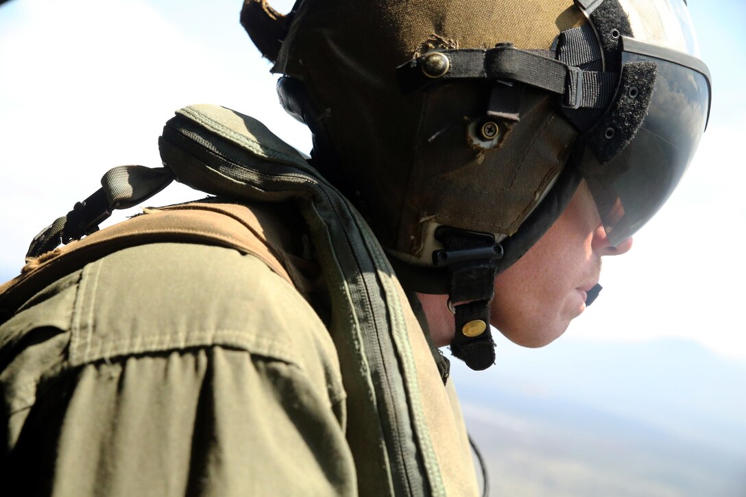 Cpl. Christopher Neumann looks at the terrain during a close air support exercise over Pohakuloa Training Area, Hawaii, July 19, 2016. Neumann is participating in Rim of the Pacific 2016, a multinational military exercise, from June 29 to Aug. 8 in and around the Hawaiian Islands. RIMPAC offers the U.S. military the opportunity to train with partners and allies in the Pacific region. Neumann, a native of Wells, Maine, is a UH-1Y Huey crew chief with Marine Light Attack Helicopter Squadron 367, which supports III Marine Expeditionary Force. (U.S. Marine Corps Photo by Cpl. Natalie A. Dillon)