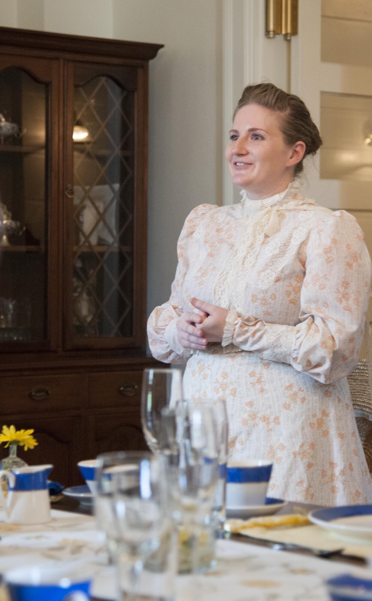 Jessica Thompson, Warren Spouses club member, talks about the fine dinnerware in a historic home on F.E. Warren Air Force Base, Wyo., July 24, 2016, during the base's annual open house, Fort D.A. Russell Days. WSC members guide the tours of historic homes each year during the open house. (U.S. Air Force photo by Senior Airman Jason Wiese)