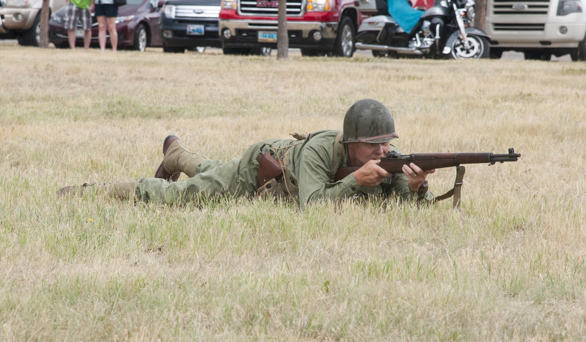 A re-enactor portrays an American World War II soldier firing at Nazis from a prone position July 24, 2016, during Fort D.A. Russell Days, the annual F.E. Warren Air Force Base, Wyo., open house. The re-enactment depicted a downed 8th Air Force pilot rescued by Allied troops from German soldiers in occupied France. (U.S. Air Force photo by Senior Airman Jason Wiese)