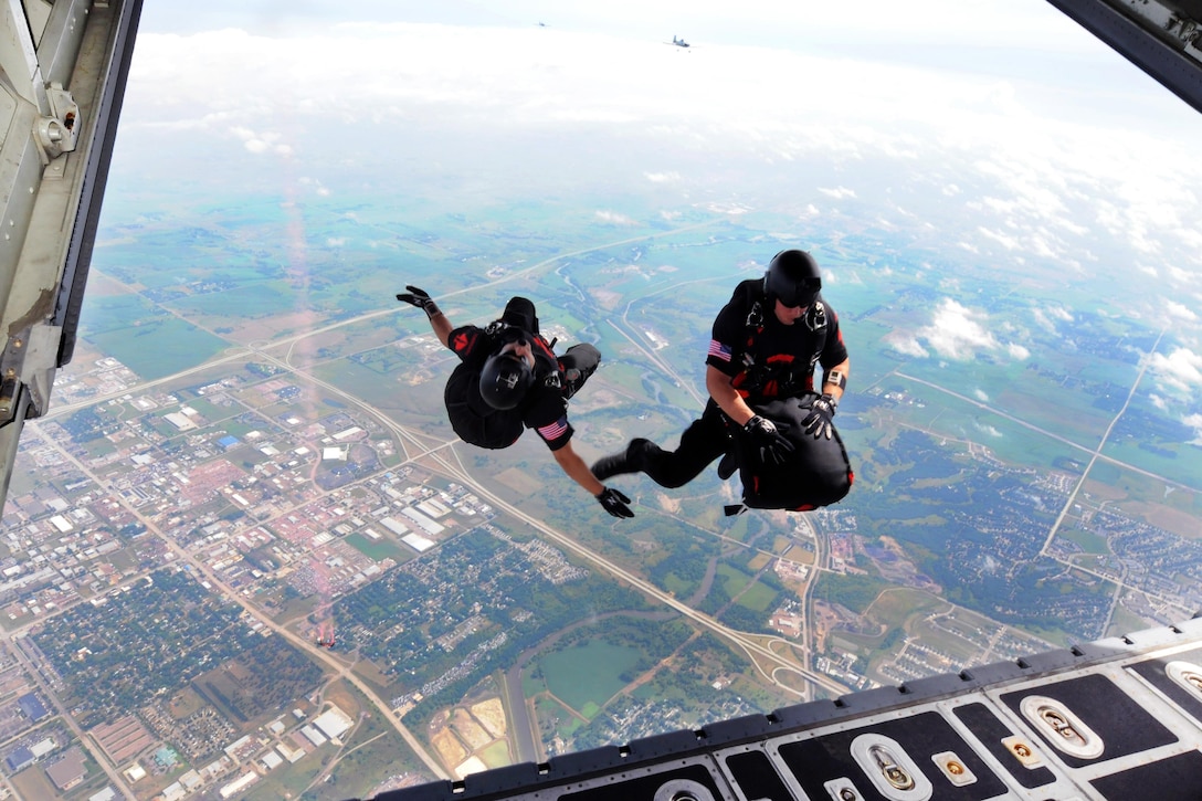 Soldiers jump from an Air Force C-130 Hercules during a performance at the Sioux Falls Air Show in Sioux Falls, S.D., July 23, 2016. The soldiers are assigned to the Black Daggers, the Army's Special Operations Command parachute demonstration team. The event marks the 70th anniversary of the South Dakota Air National Guard. Air National Guard photo by Master Sgt. Christopher Stewart