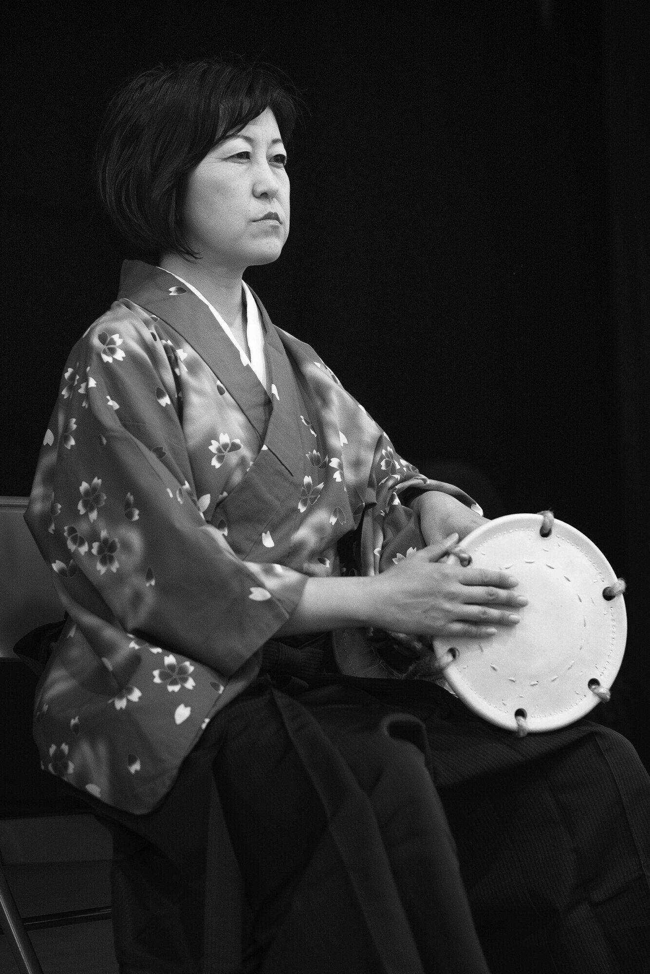 Akiko Iwasaki, Tsuzumi Do Group member, performs in front of children and parents at the middle school of Yokota Air Base, Japan, July 18, 2016. The Tsuzumi Do Group, a traditional Japanese hand drum team, visited Yokota Middle School children and their parents to perform and share how to play the instrument. (U.S. Air Force photo by Senior Airman Delano Scott/Released)