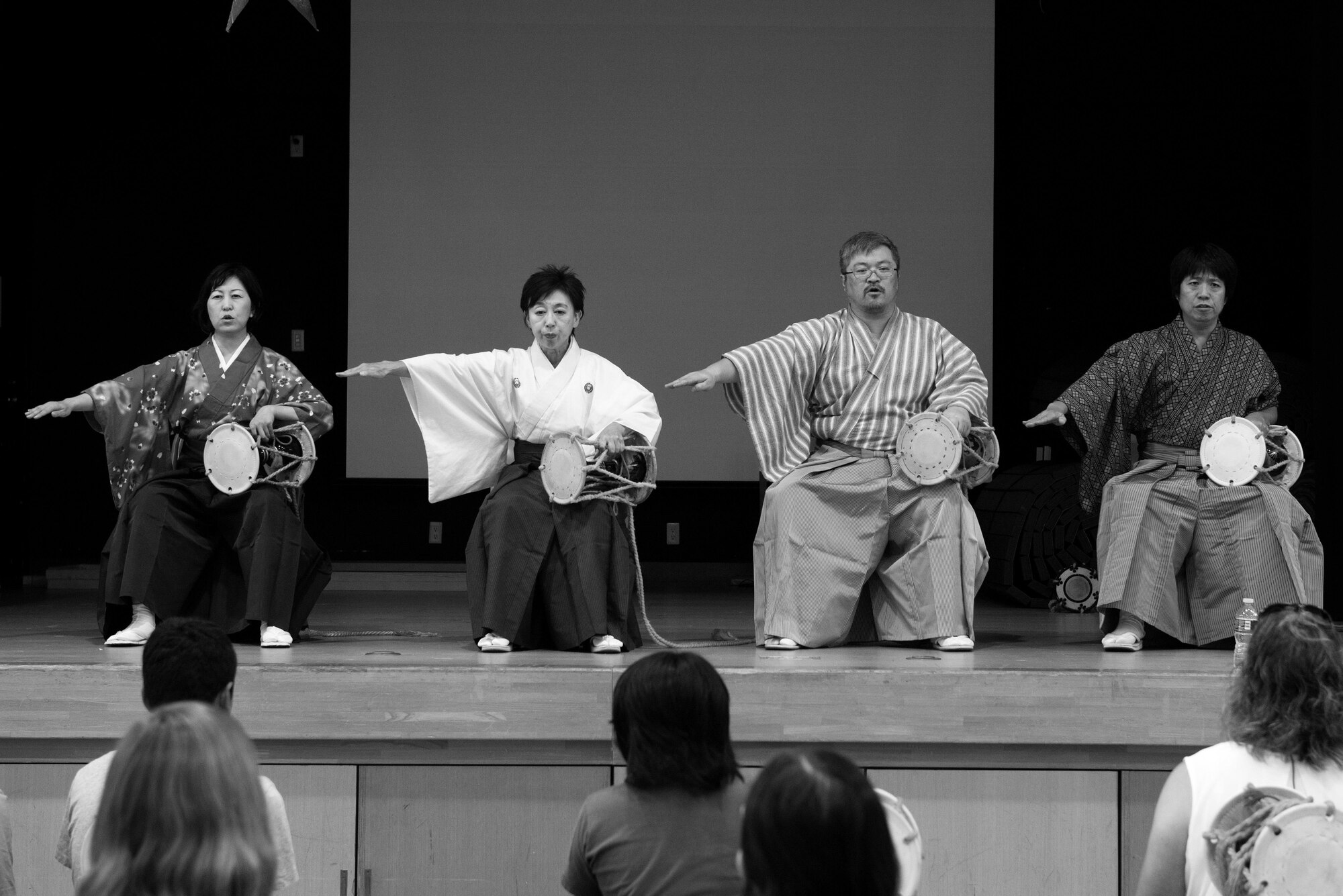 Tsuzumi Do Group members perform in front of children and parents at the middle school of Yokota Air Base, Japan, July 18, 2016. The Tsuzumi Do Group, a traditional Japanese hand drum team, visited Yokota Middle School children and their parents to perform and share how to play the instrument. (U.S. Air Force photo by Senior Airman Delano Scott/Released)