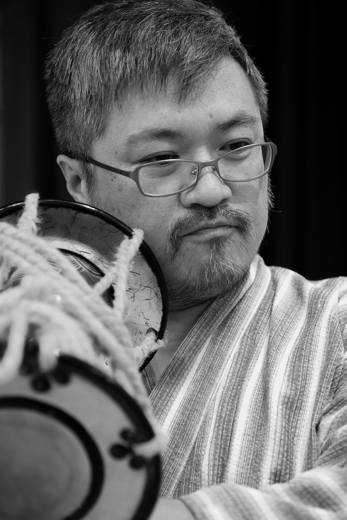 Kenji Ushimoto, Tsuzumi Do Group member, demonstrates how to use a tsuzumi drum at the middle school of Yokota Air Base, Japan, July 18, 2016. The playing of the tsuzumi drum in meant to demonstrate the harmony and unity between people and nature. (U.S. Air Force photo by Senior Airman Delano Scott/Released)