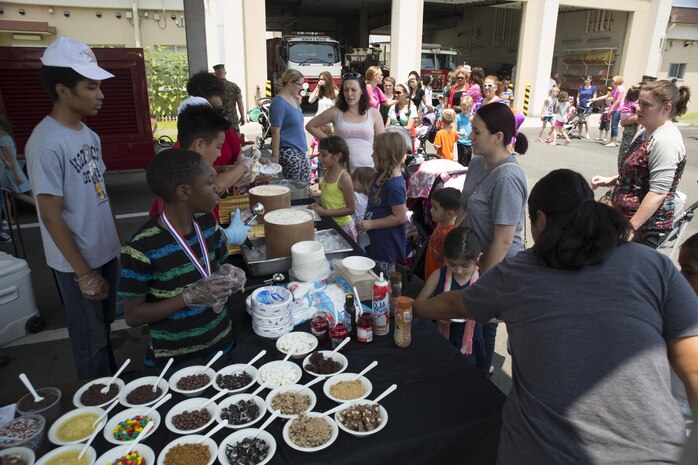 Families line up for ice cream while attending the Fire and Ice ice cream social at Marine Corps Air Station Iwakuni, Japan, July 20, 2016. The Exceptional Family Member Program hosted the event in collaboration with the MCAS Iwakuni Fire Department at Fire Station Four, where Japanese firemen and air station residents participated in family activities. (U.S. Marine Corps photo by Lance Cpl. Donato Maffin)