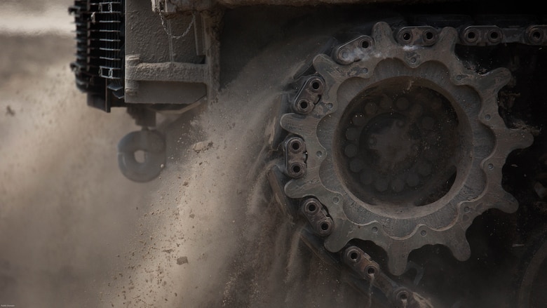 The treads of an M1A1 battle tank with Fox Company, 4th Tank Battalion, kick up dirt and debris as it makes its way downrange at Engineer Training Area 2 during a training exercise on Marine Corps Base Camp Lejeune, N.C., July 21, 2016. The intent was to bring the active and reserve Marines together to train in the event they deploy as one battalion in the future. 