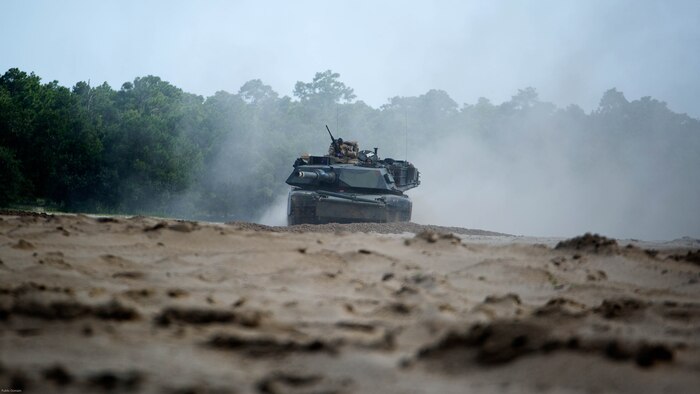 An M1A1 Abrams battle tank with Fox Company, 4th Tank Battalion, drives to an objective as a part of a combined arms breaching exercise at Marine Corps Base Camp Lejeune N.C., July 22, 2016. Elements from a Marine engineer unit worked with 4th Tanks to clear obstacles to make way for the infantry. 