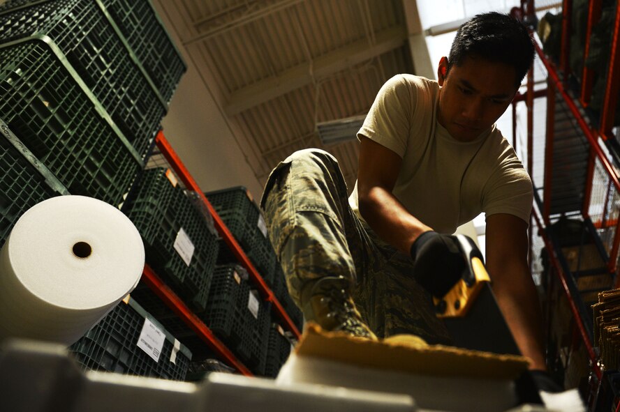 U.S. Air Force Airman 1st Class Emanuel Castro, 20th Logistics Readiness Squadron individual protective equipment apprentice, cuts foam using a hand-saw at Shaw Air Force Base, S.C., July 25, 2016. The foam is cut into strips and placed between flak vest plates to protect and preserve their serviceability. (U.S. Air Force photo by Airman 1st Class Christopher Maldonado) 