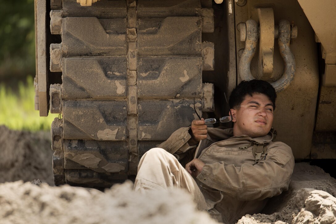 Lance Cpl. Hugo Orozco, an M88A2 Hercules tank mechanic with Fox Company, 4th Tank Battalion, rests under the shade of his vehicle at Engineer Training Area 2 during a training exercise on Camp Lejeune, N.C., July 21, 2016. The intent was to bring the active and reserve Marines together to train in the event they deploy as one battalion in the future. (U.S. Marine Corps photo by Sgt. Matthew Callahan)