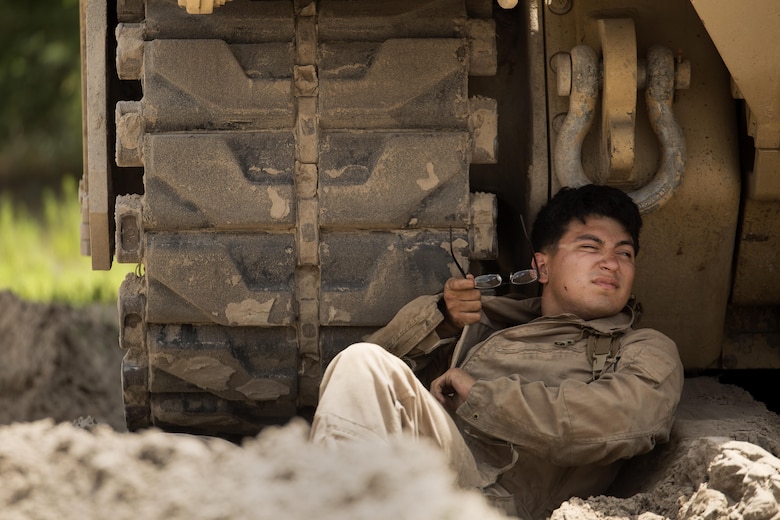 Lance Cpl. Hugo Orozco, an M88A2 Hercules tank mechanic with Fox Company, 4th Tank Battalion, rests under the shade of his vehicle at Engineer Training Area 2 during a training exercise on Camp Lejeune, N.C., July 21, 2016. The intent was to bring the active and reserve Marines together to train in the event they deploy as one battalion in the future. (U.S. Marine Corps photo by Sgt. Matthew Callahan)