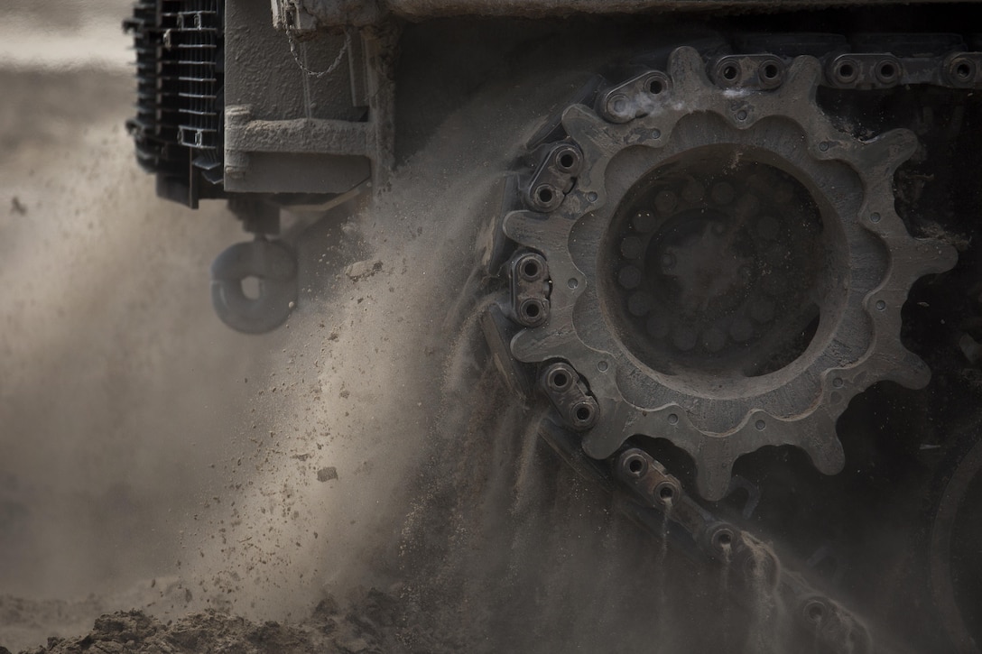 The treads of an M1A1 battle tank with Fox Company, 4th Tank Battalion, kick up dirt and debris as it makes its way downrange at Engineer Training Area 2 during a training exercise on Camp Lejeune, N.C., July 21, 2016. The intent was to bring the active and reserve Marines together to train in the event they deploy as one battalion in the future. (U.S. Marine Corps photo by Sgt. Matthew Callahan)