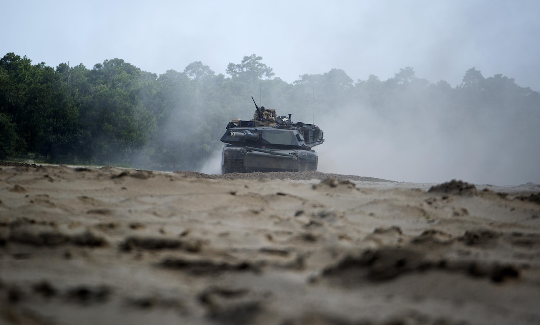 An M1A1 Abrams battle tank with Fox Company, 4th Tank Battalion, drives to an objective as a part of a combined arms breaching exercise at Camp Lejeune N.C., July 22, 2016. Elements from a Marine engineer unit worked with 4th Tanks to clear obstacles to make way for the infantry. (U.S. Marine Corps photo by Pfc. Juan Soto-Delgado)