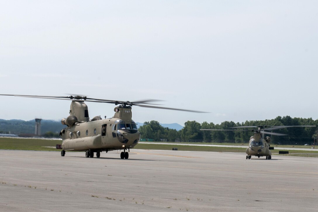 Army CH-47 Chinook helicopters land at the Army Aviation Support Facility in South Burlington, Vt., July 20, 2016. The helicopter crews, assigned to the Connecticut National Guard’s Company B, 2nd Battalion, 104th Aviation Regiment, are transporting Vermont National Guardsmen to Fort Drum, N.Y. Army National Guard photo by Spc. Avery Cunningham