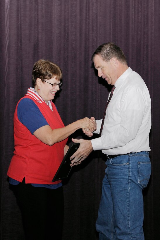 Retiring DLA Disposition Services employee Wendy Kropp surprises activity director Mike Cannon with the “Beautiful Battle Creek Award” July 22. 