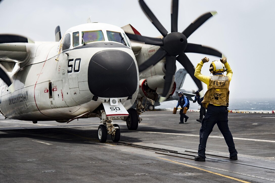 Navy Petty Officer 1st Class Jeremy Parrish directs a C2-A Greyhound on the flight deck of the aircraft carrier USS Dwight D. Eisenhower in the Arabian Sea, July 19, 2016. Parrish is an aviation boatswain's mate, handling. The Greyhound is assigned to Fleet Logistics Support Squadron 40. Navy photo by Petty Officer 3rd Class Anderson W. Branch